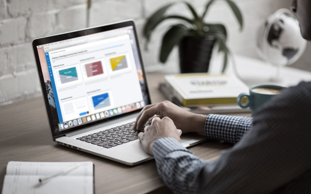 A man in a dress shirt sits at a desk on his laptop. On the screen, is ShopMessage's growth tools strategy selection page. The man contemplates his choice.